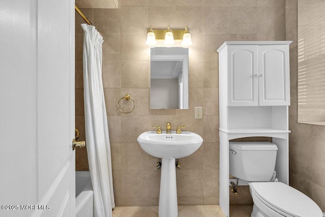 bathroom with tile walls, shower / bath combination with curtain, ornamental molding, and toilet