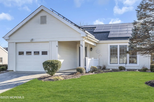 view of front of property featuring a garage, a front lawn, and solar panels