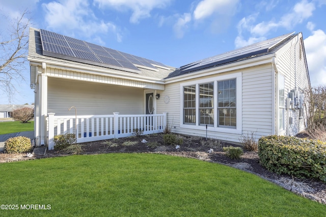 view of front facade featuring a front lawn and solar panels