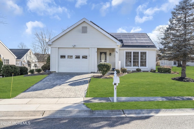 ranch-style house with a garage, solar panels, and a front yard