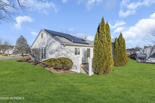 view of home's exterior with a yard and solar panels