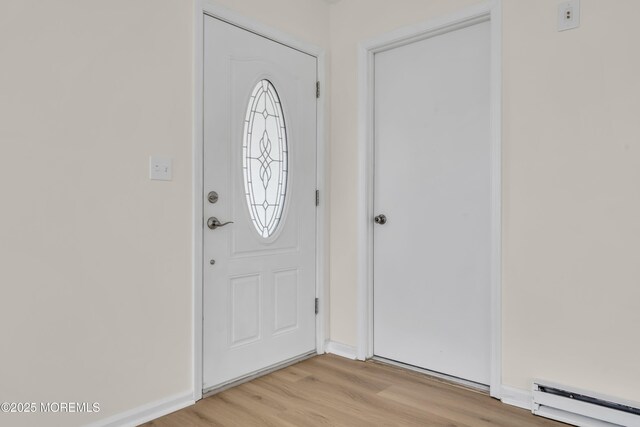 entryway featuring a baseboard heating unit and light hardwood / wood-style floors