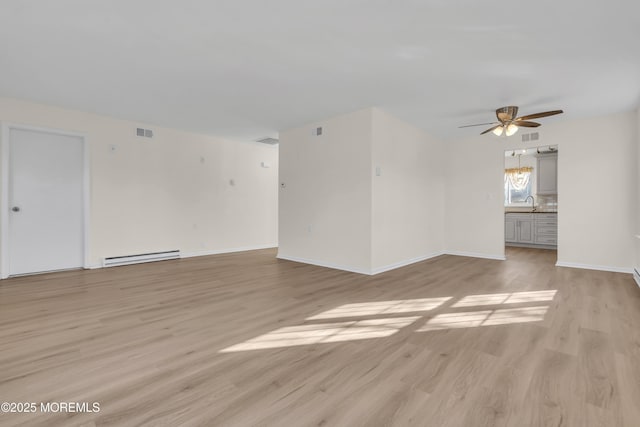 spare room with ceiling fan, a baseboard radiator, sink, and light wood-type flooring