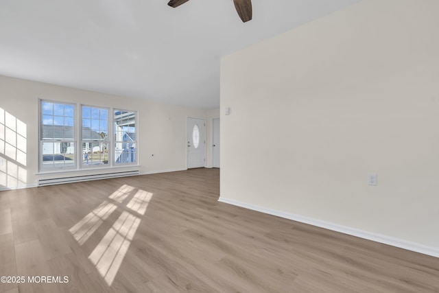 unfurnished living room with a baseboard heating unit, ceiling fan, and light wood-type flooring