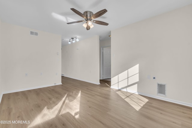 spare room with ceiling fan, track lighting, and light hardwood / wood-style flooring