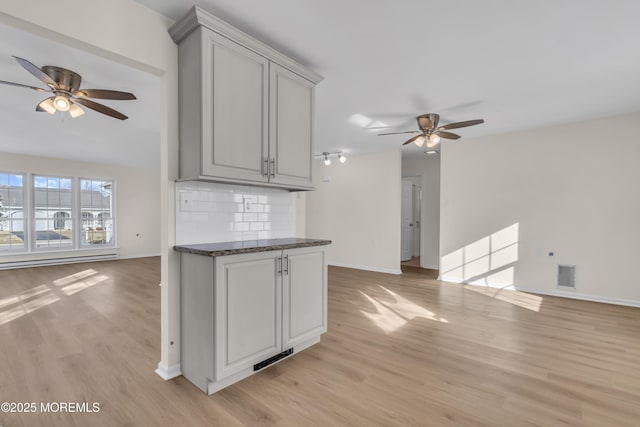 kitchen featuring ceiling fan, light hardwood / wood-style floors, and tasteful backsplash