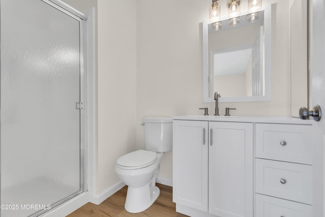 bathroom featuring walk in shower, vanity, toilet, and hardwood / wood-style flooring