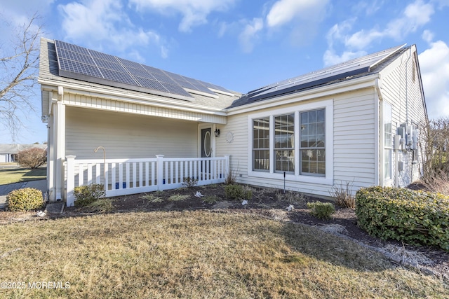 view of front facade featuring a front lawn and solar panels