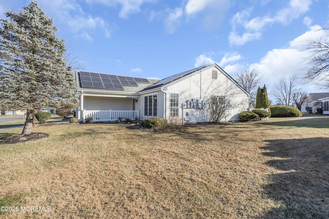 back of property featuring solar panels, a yard, and a porch