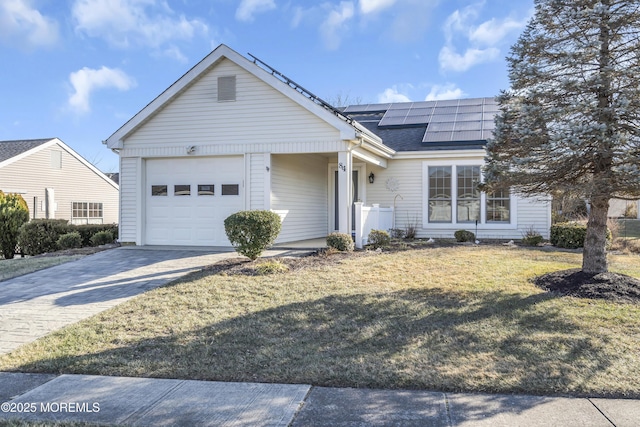 ranch-style home with a front lawn, a garage, and solar panels