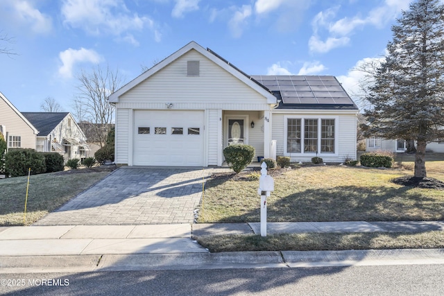 ranch-style house with solar panels and a garage