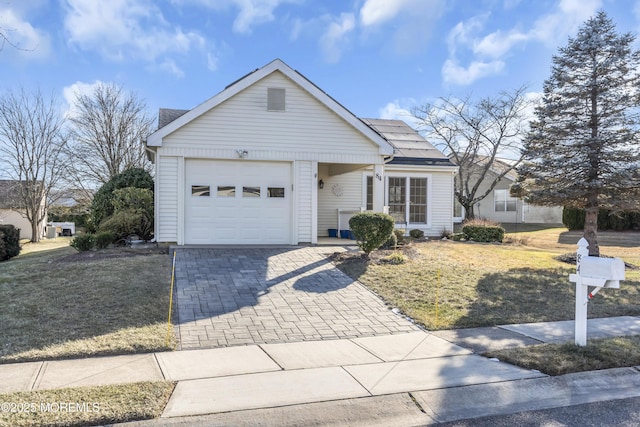 ranch-style home with a front lawn and a garage