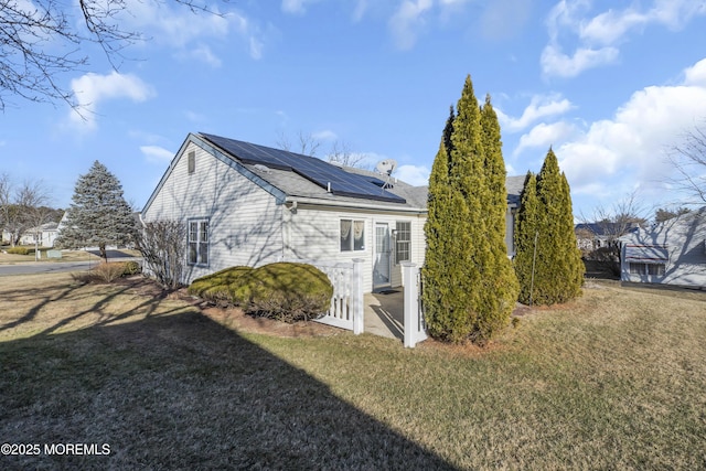 view of property exterior with a yard and solar panels