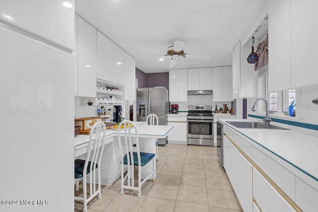 kitchen with white cabinetry, stainless steel appliances, sink, light tile patterned flooring, and ceiling fan