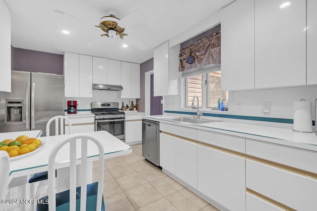 kitchen with white cabinetry, stainless steel appliances, sink, ceiling fan, and light tile patterned floors