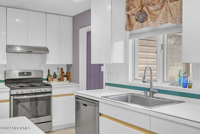 kitchen with appliances with stainless steel finishes, white cabinetry, and sink