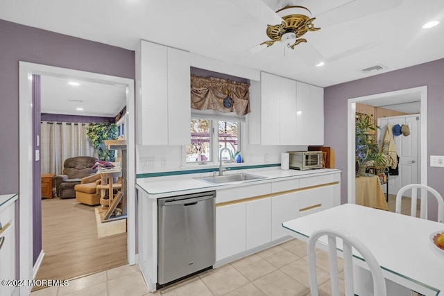 kitchen featuring ceiling fan, stainless steel dishwasher, sink, light tile patterned flooring, and white cabinetry