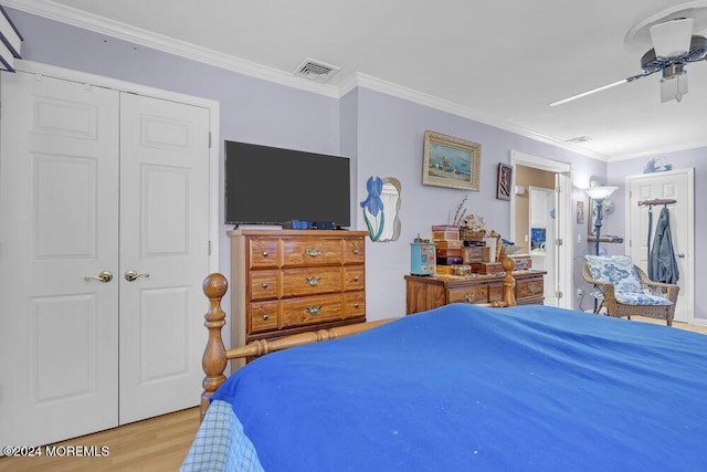 bedroom with ceiling fan, crown molding, light hardwood / wood-style floors, and a closet