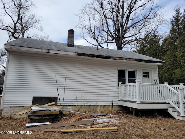 rear view of property featuring a wooden deck