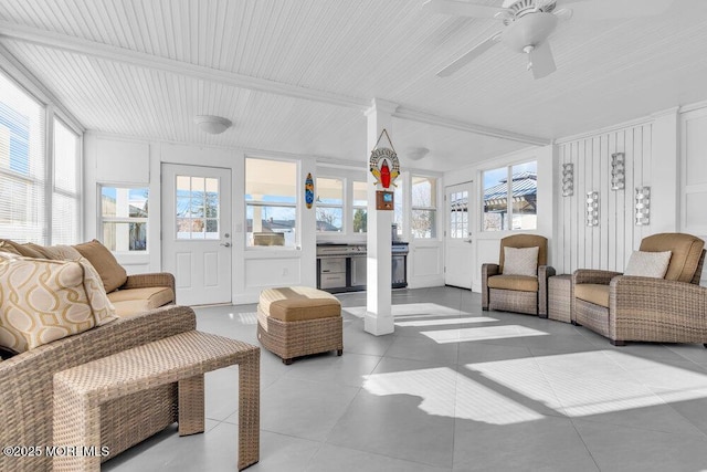 tiled living room featuring ceiling fan and beam ceiling