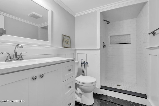 bathroom with toilet, vanity, ornamental molding, and a tile shower