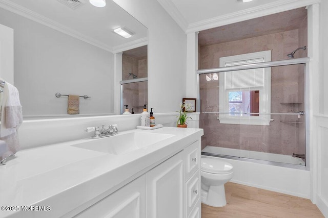 full bathroom featuring combined bath / shower with glass door, vanity, crown molding, and toilet