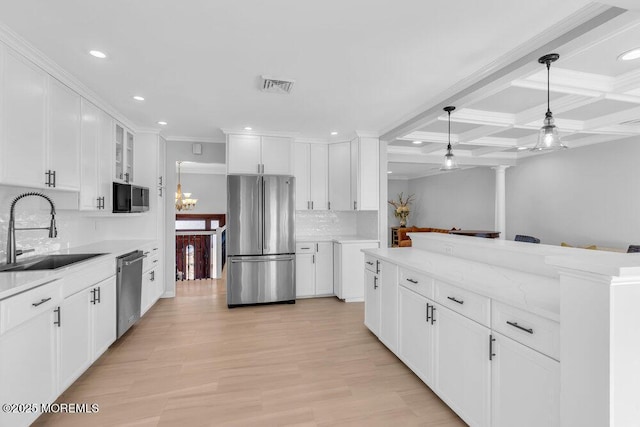 kitchen featuring stainless steel appliances, decorative backsplash, white cabinetry, and sink