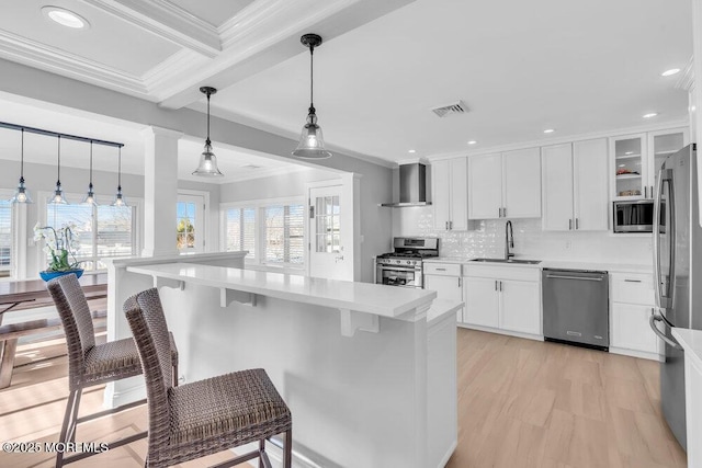 kitchen featuring white cabinets, appliances with stainless steel finishes, decorative light fixtures, beamed ceiling, and sink