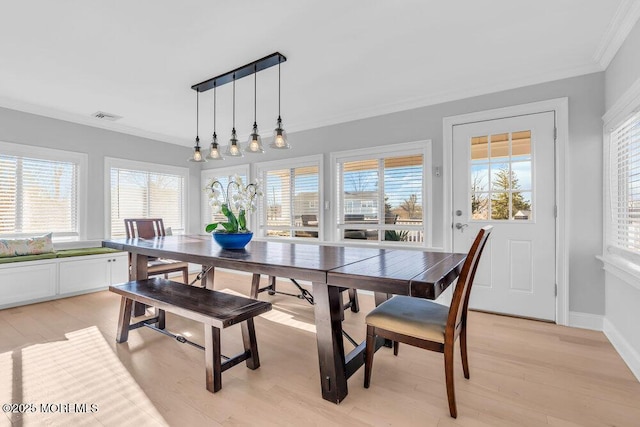 dining space with light wood-type flooring and crown molding