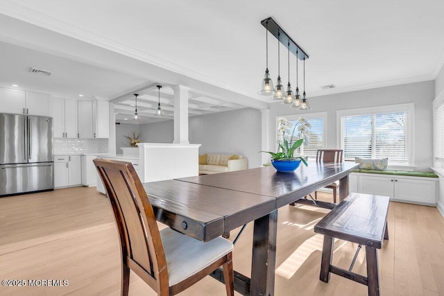 dining space featuring light hardwood / wood-style floors, ornamental molding, beam ceiling, and coffered ceiling