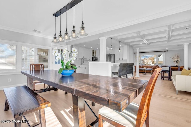 dining area with light hardwood / wood-style floors, beam ceiling, sink, coffered ceiling, and ornamental molding