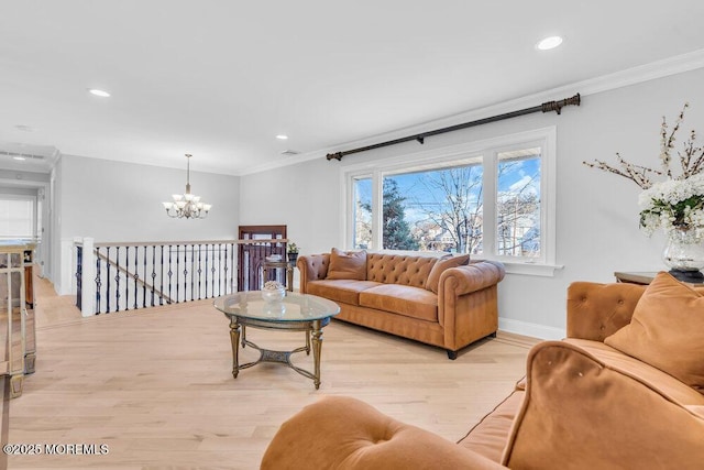 living room featuring plenty of natural light, crown molding, a chandelier, and light wood-type flooring