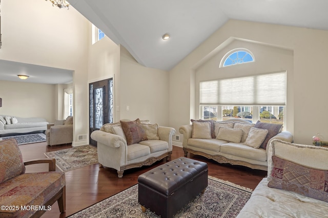 living room with high vaulted ceiling and dark wood-type flooring