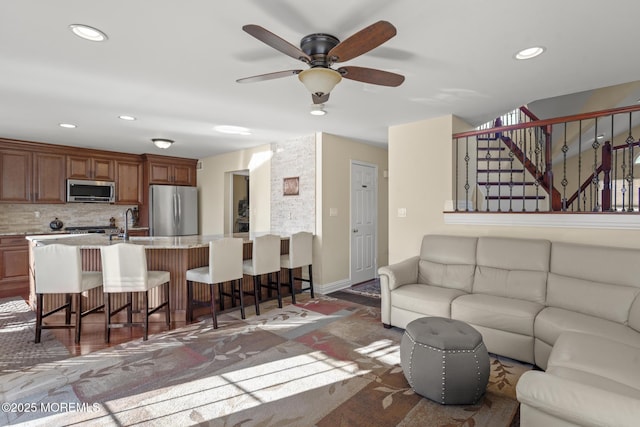 carpeted living room with sink and ceiling fan