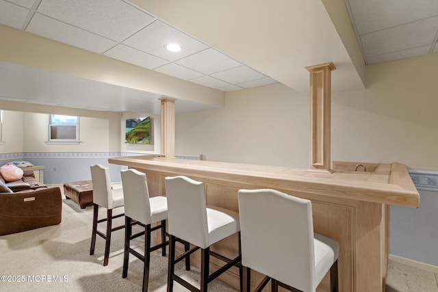 bar featuring light colored carpet and a drop ceiling