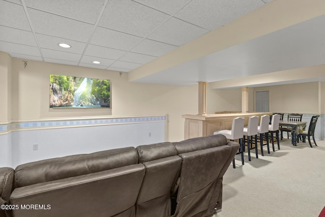 carpeted living room featuring a paneled ceiling