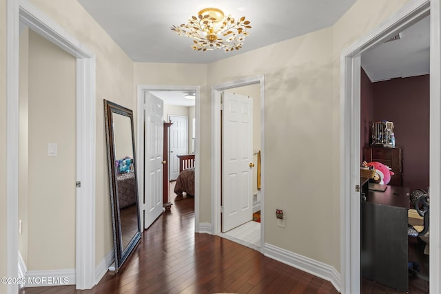 corridor featuring hardwood / wood-style floors and an inviting chandelier