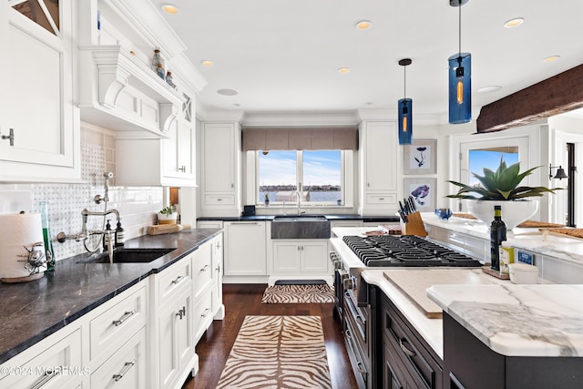 kitchen featuring sink, pendant lighting, dark stone counters, and white cabinets