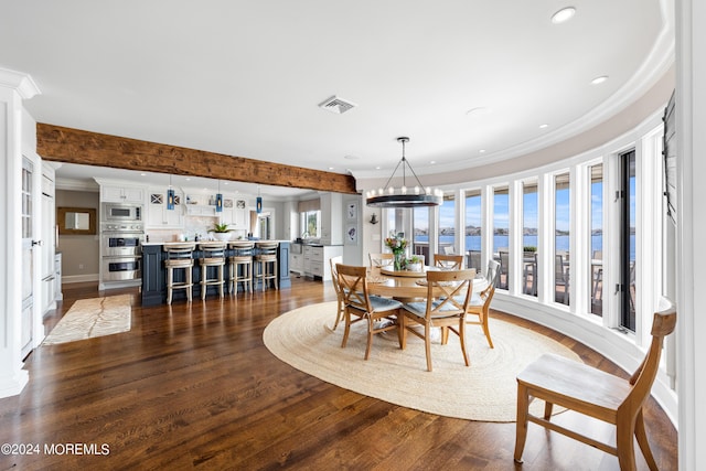 dining room featuring ornamental molding, dark wood-type flooring, a water view, and a wealth of natural light