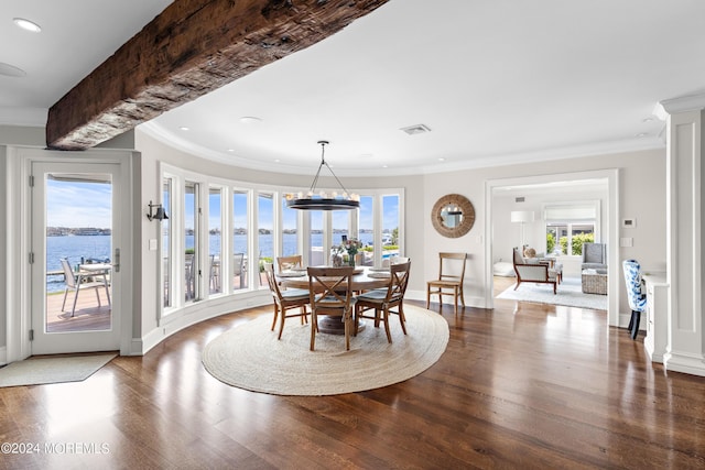 dining area featuring hardwood / wood-style flooring, crown molding, and a water view