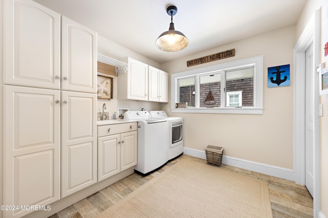 clothes washing area with sink, cabinets, and washing machine and dryer