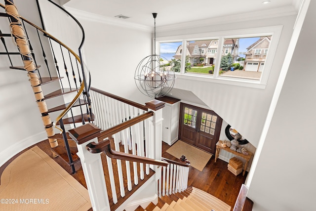 stairs featuring an inviting chandelier, crown molding, and wood-type flooring