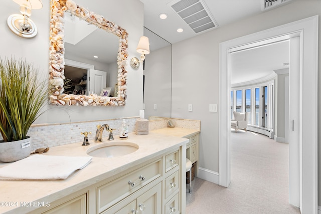 bathroom featuring a baseboard radiator, backsplash, and vanity