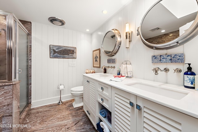 bathroom with toilet, vanity, wood walls, and walk in shower