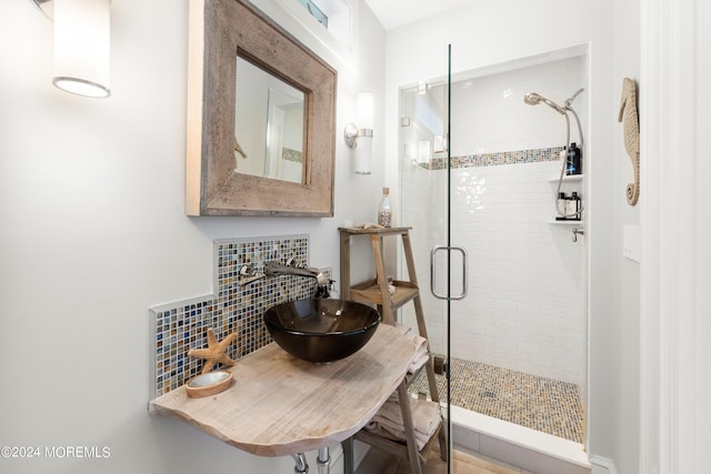 bathroom with an enclosed shower, backsplash, and sink