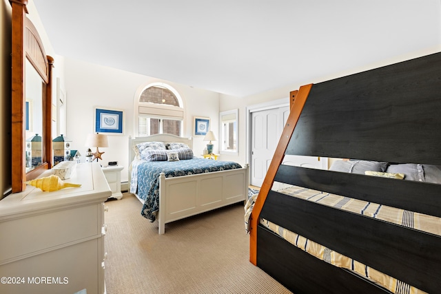 bedroom featuring light colored carpet and a closet