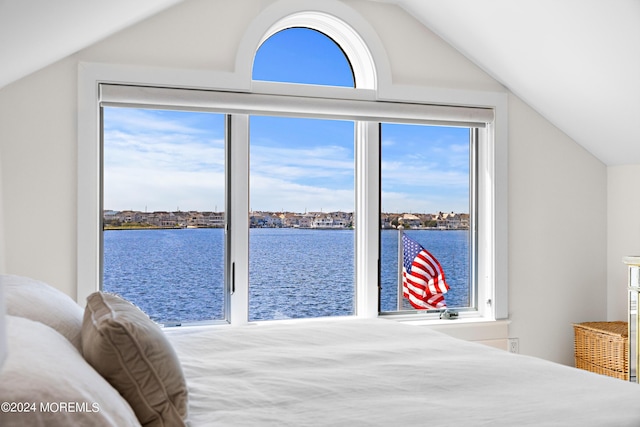 bedroom with vaulted ceiling and a water view