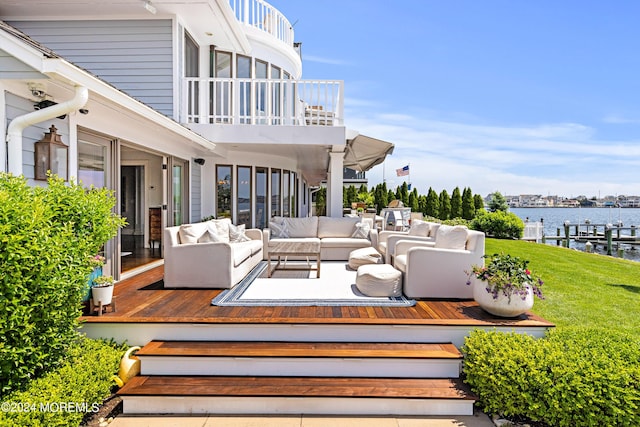 wooden terrace featuring an outdoor hangout area, a yard, and a water view