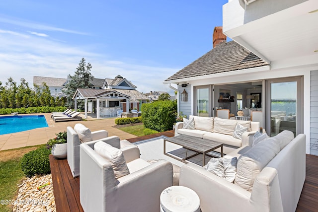 view of pool with an outbuilding, an outdoor living space, and a patio