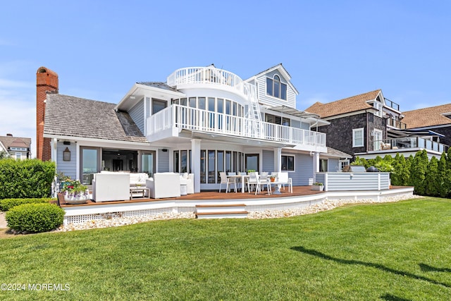 back of property with a balcony, a yard, a wooden deck, and an outdoor living space